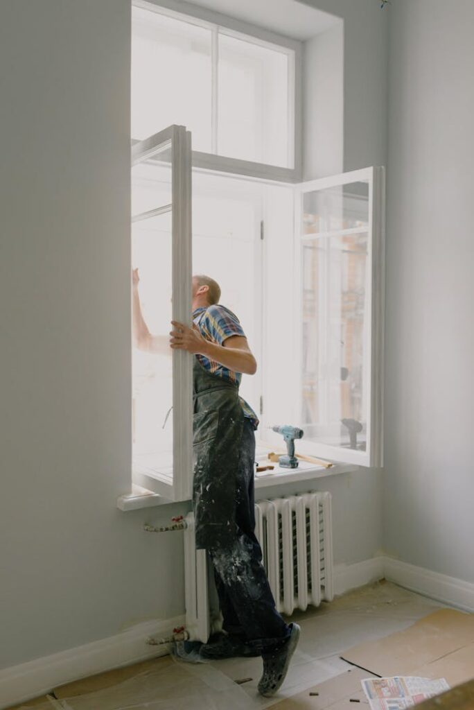 pexels-photo-5691521 Professional installing a window in a bright modern apartment interior.